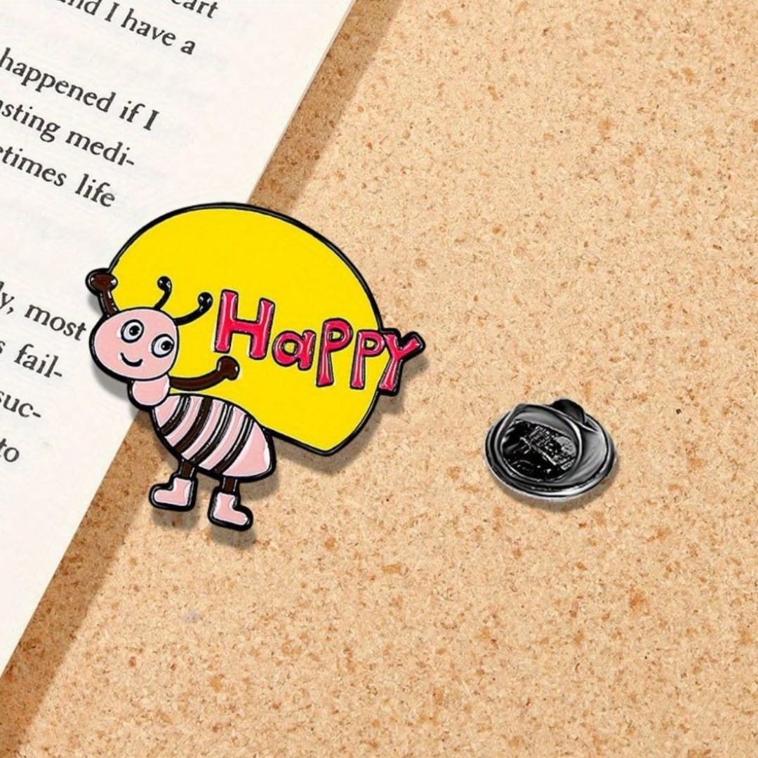 Bee Happy cute enamel lapel pin with yellow balloon and red Happy text on canvas background
