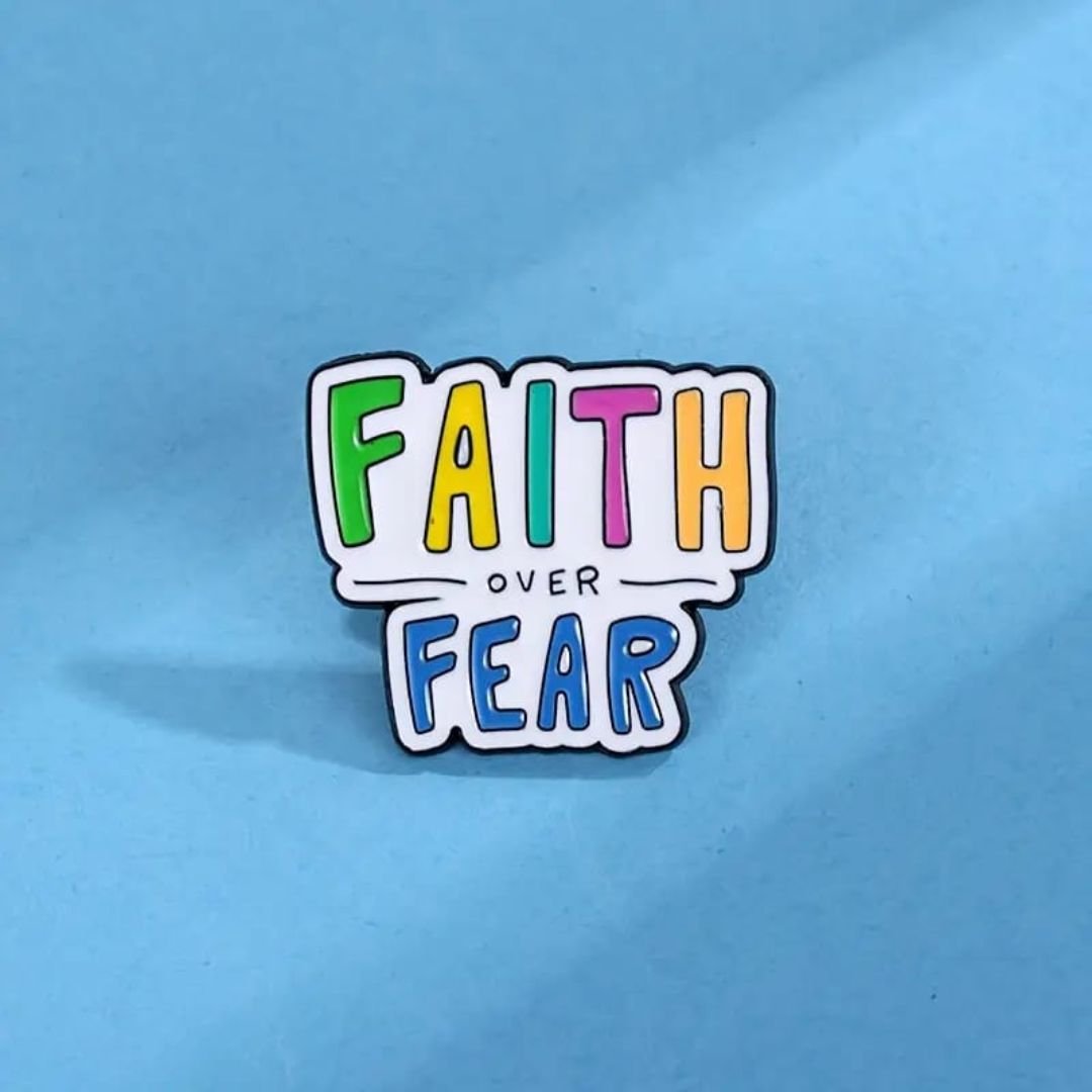 Faith Over Fear enamel pin with colourful lettering and dark outline.