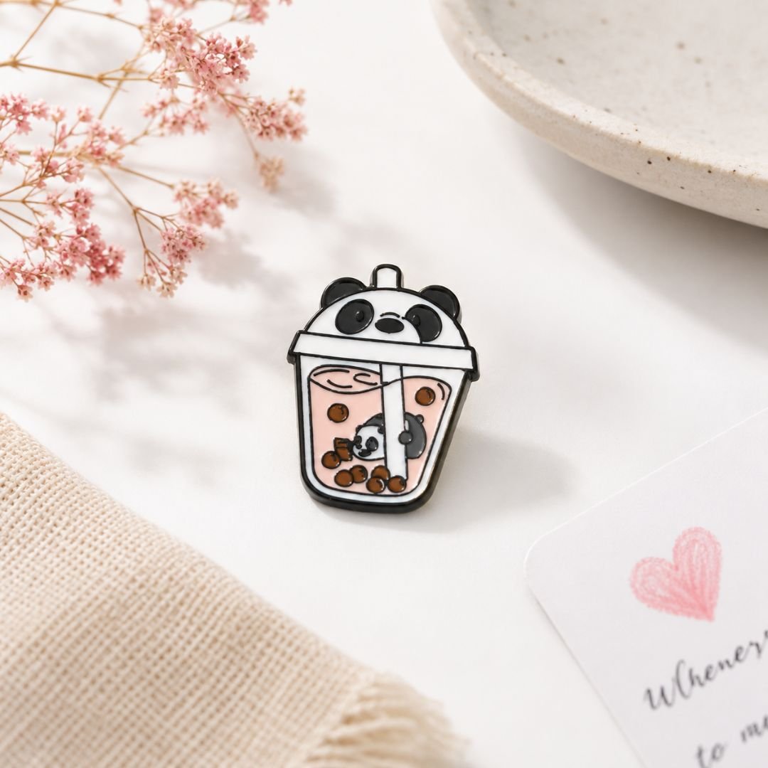 Panda bubble tea enamel pin kawaii boba lapel pin white lifestyle flat lay pink dried flowers heart card